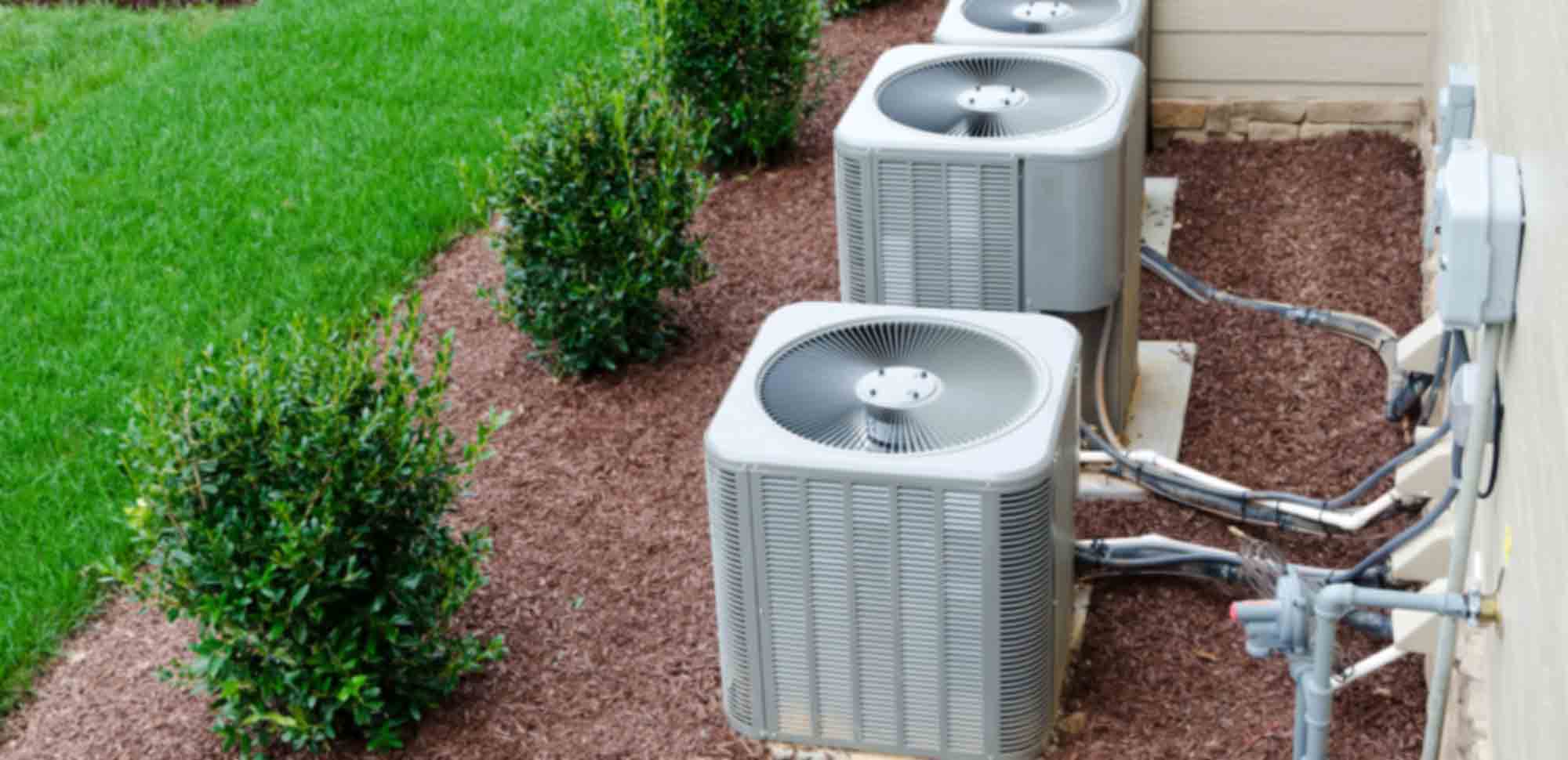 Four air conditioning units with piping on lawn, near Southwest Florida Electric Inc. installations.