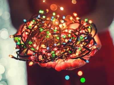 Colorful LED Christmas lights held in hands, symbolizing energy-efficient holiday decorations for festive celebrations.
