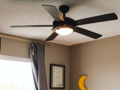 Ceiling fan with light fixture installed in a modern interior, enhancing air circulation and comfort, relevant to electrical home improvements for 2024.
