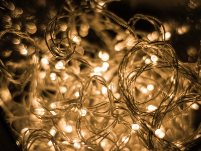 Warm glowing holiday lights tangled together, emphasizing the importance of inspecting electrical decorations for safety during Halloween and festive seasons.