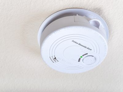 Carbon monoxide detector mounted on ceiling, highlighting home safety equipment essential for detecting dangerous gas and preventing hazards.