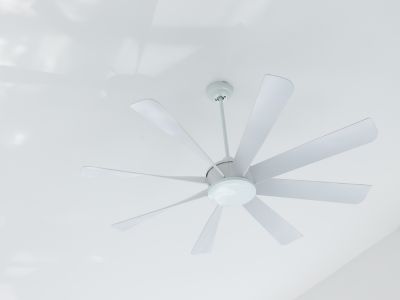Ceiling fan installed on a white ceiling, illustrating energy-efficient home improvement for comfort and cost savings in heating and cooling.